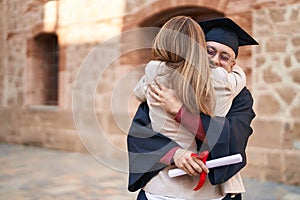 Man and woman mother and son hugging each other celebrating graduation at university