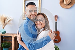 Man and woman mother and son hugging each other at home