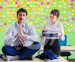 Man and woman in the office with many conflicting priorities in