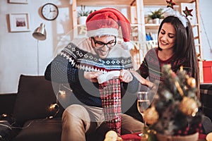 Man and woman opens Christmas gift at home
