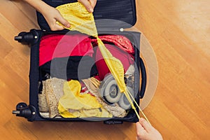 A man and a woman packing a suitcase or luggage for travel. Concept