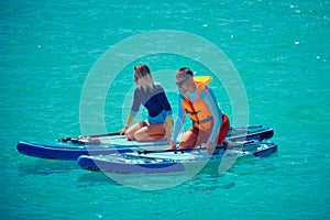 Man and woman paddling on sup boards