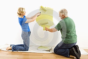 Man and woman painting wall.