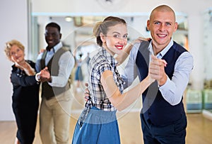 Man and woman performing ballroom dance in dancing room