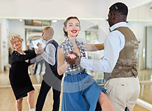 Man and woman performing jazz dance in dancing room