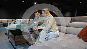 Man and woman picking upholstery materials in furniture store