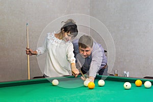 Man and woman play billiards.