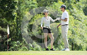 Man and woman playing golf on a beautiful natural golf course