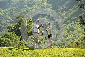 Man and woman playing golf on a beautiful natural golf course