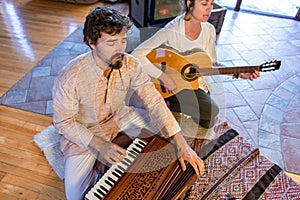 Man and woman playing guitar and harmonium