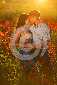 Man and woman in poppy field at sunset, romance