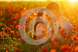 Man and woman in poppy field at sunset, romance