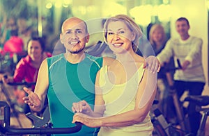 Man and woman posing in a gym and smiling