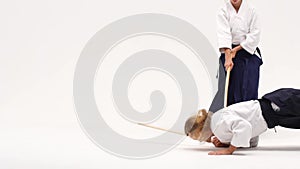 Man and woman practicing aikido using bokken. Isolated on white. Close up. Slow motion.