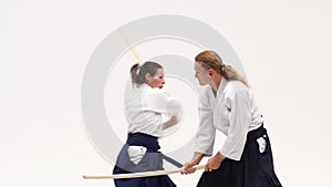 Man and woman practicing aikido using bokken. Isolated on white. Close up. Slow motion.