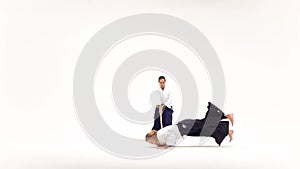 Man and woman practicing aikido using bokken. Isolated on white. Slow motion.