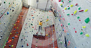 Man and woman practicing rock climbing in fitness studio 4k