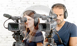 A man and a woman with professional video cameras