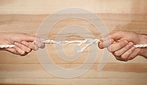 Man and woman pulling frayed rope at breaking point