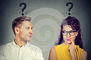 Man and woman with question mark looking at each other with interest