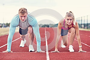 Man and woman racing on outdoor track