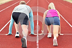 Man and woman racing on outdoor track