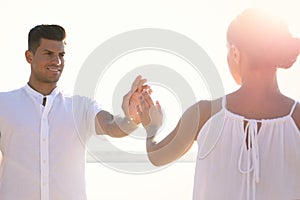 Man and woman reaching hands to each other near river. Nature healing power