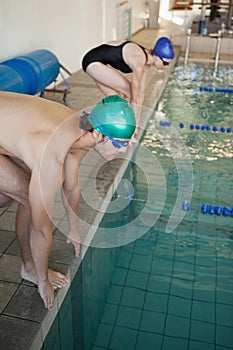 Man and woman ready to dive in the pool