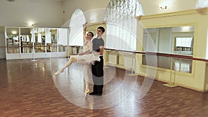 Man and woman rehearse ballet moves, take break from dancing