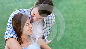 Man, woman and relax embrace in park for summer holiday or partnership vacation for sunshine, date or weekend. Happy