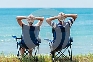 Man and woman relax and unwind in camping chairs