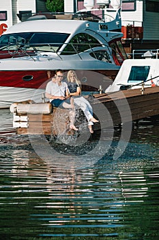 Man and woman relaxing on a berth in yacht club.