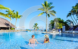 Man and Woman relaxing in a swimming pool, a couple on a honeymoon vacation in Mauritius