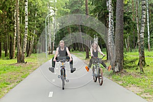 Man and woman ride bikes through the woods