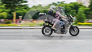 Man and woman riding on bmw f800r motorcycle. Young couple riding motorbike on city road