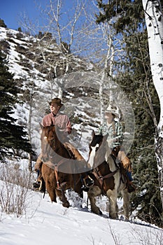 Man and Woman Riding Horses in the Snow