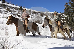 Man and Woman Riding Horses in the Snow