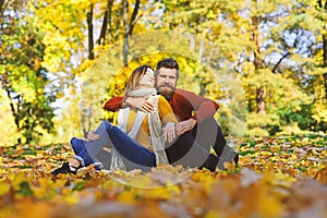 Man and woman with romantic faces on autumn trees background