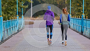 Man and woman running in park in the morning