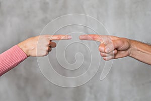 Man and woman`s fingers pointing at each other