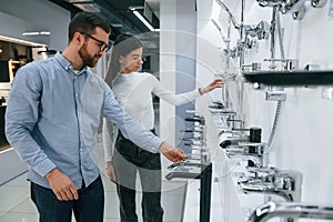 Man and woman is in sanitary ware store choosing products