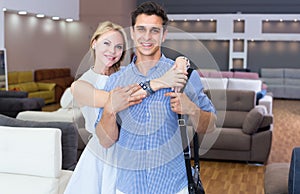 Man and woman are satisfied by buying new sofa