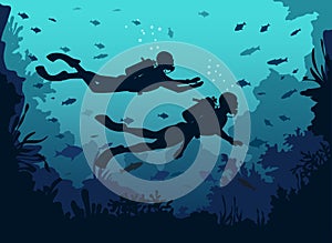 Man and woman scuba divers silhouette swimming in deep sea.