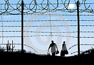 A man and woman are seen in silhouette after breaching a border fence