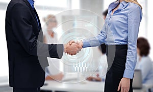 Man and woman shaking their hands in office