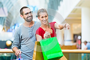 Man and woman in shopping mall with bags