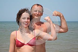 Man and woman show bicepses photo