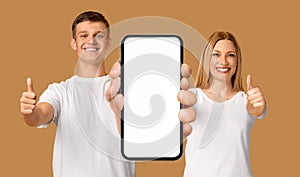 Man And Woman Showing Smartphone With Big Blank White Screen At Camera