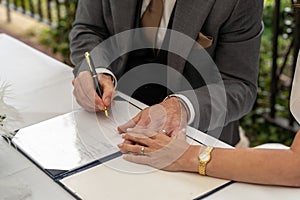 a man and woman signing papers for wedding photos and getting married