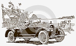 A man and a woman sitting in an antique car in front of a farm building